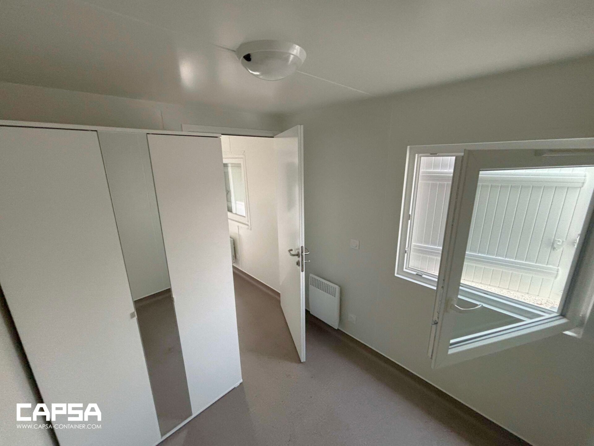 Aménagement d'un bloc sanitaire modulaire avec équipements de douche et lavabo au camp du Rondeau à Grenoble.